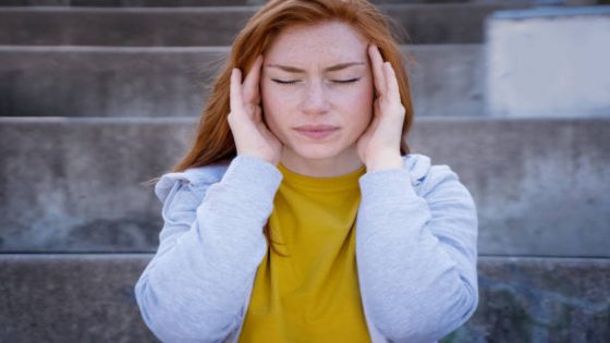 One young woman massaging temples feeling head pain