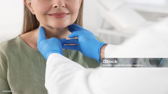 Endocrinologist examining thyroid gland of patient indoors, closeup